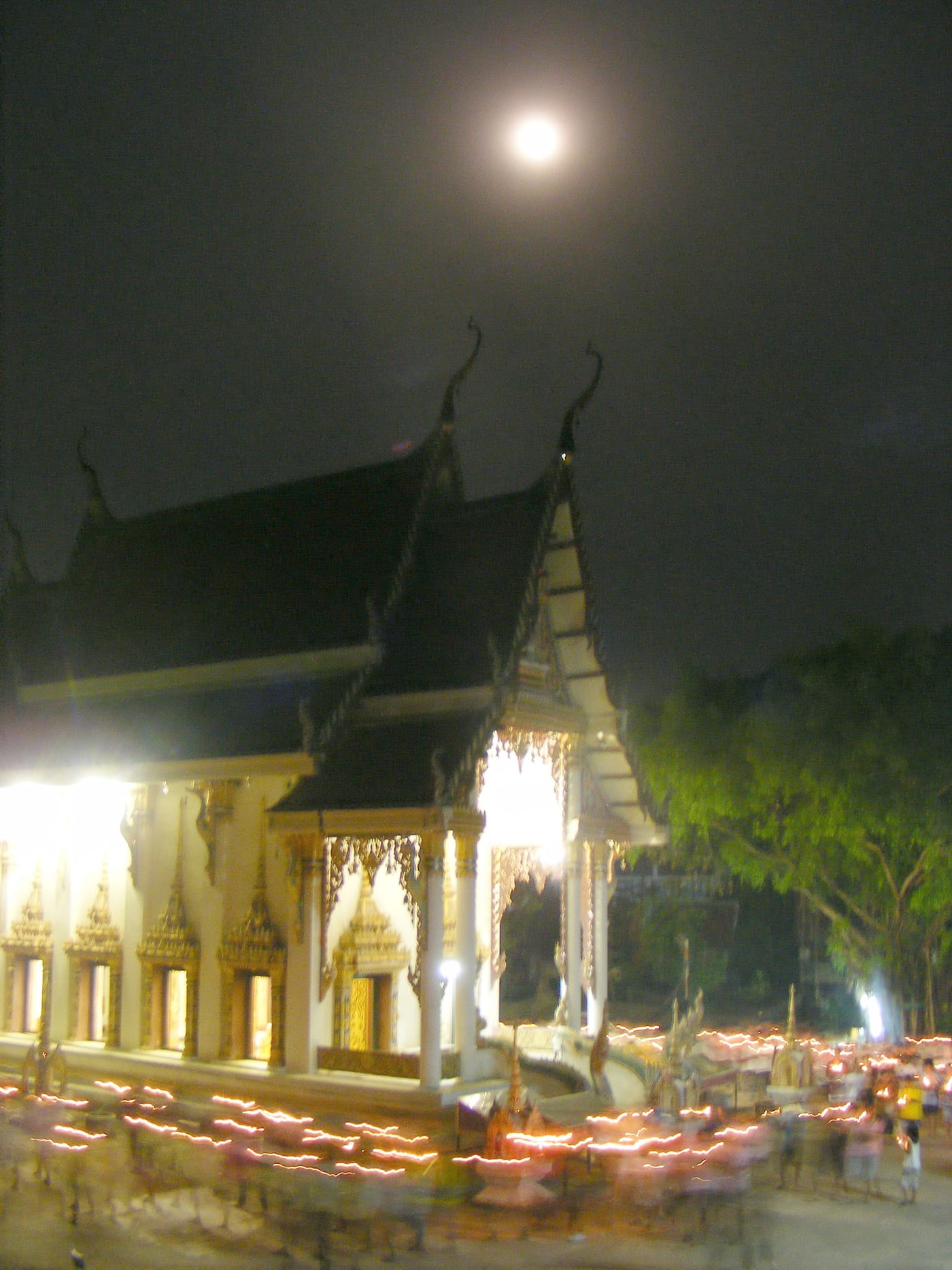 三宝佛节夜,泰国寺院信众手持明灯绕行佛殿